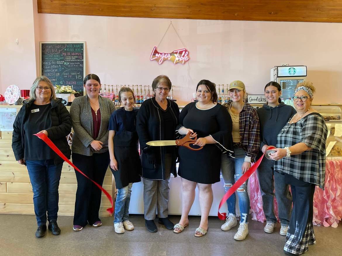 Tammy and Trisha Galloway, owners of Longer Table are joined by their staff and the Harrison Area Chamber of Commerce for a ribbon-cutting ceremony held Saturday, Nov. 18 to celebrate their business’s grand reopening.